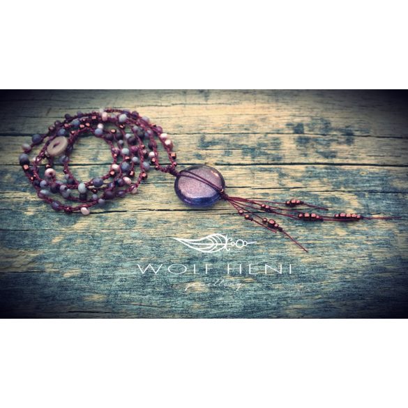 „Antik bronz felületű, fényre kék és lila árnyalatot mutató medál részletfotója”